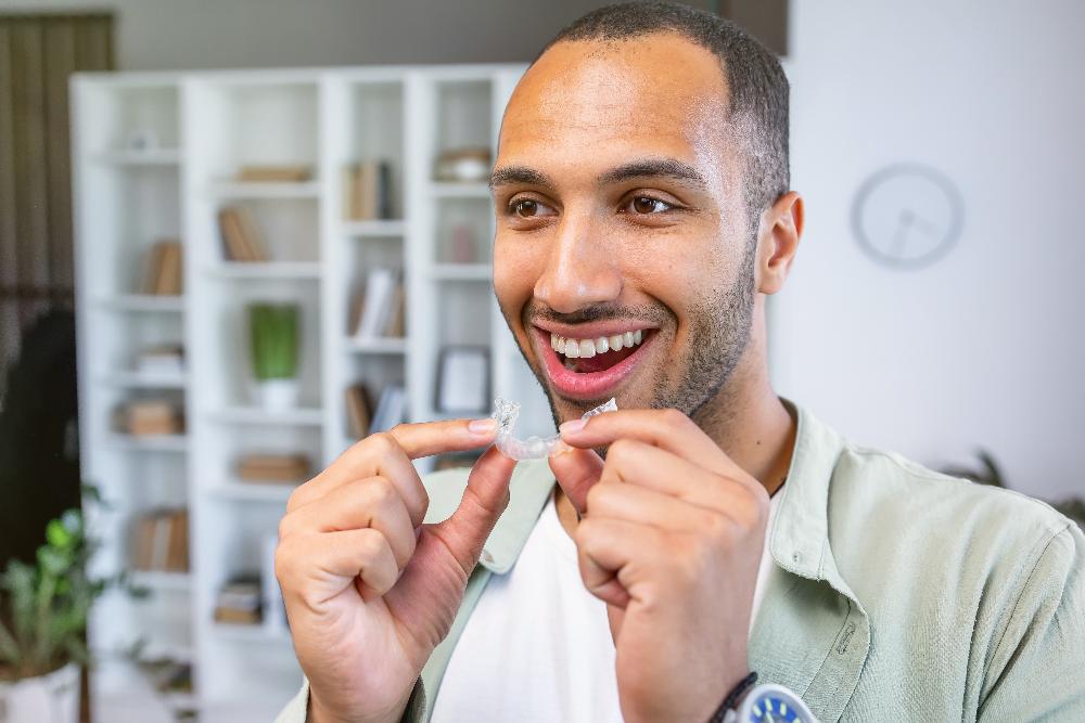 man putting in clear plastic aligner | invisalign lakeville mn