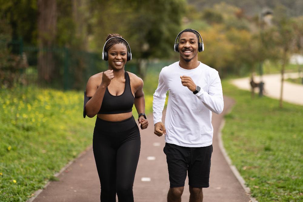 young couple running on track outside | dentures lakeville mn
